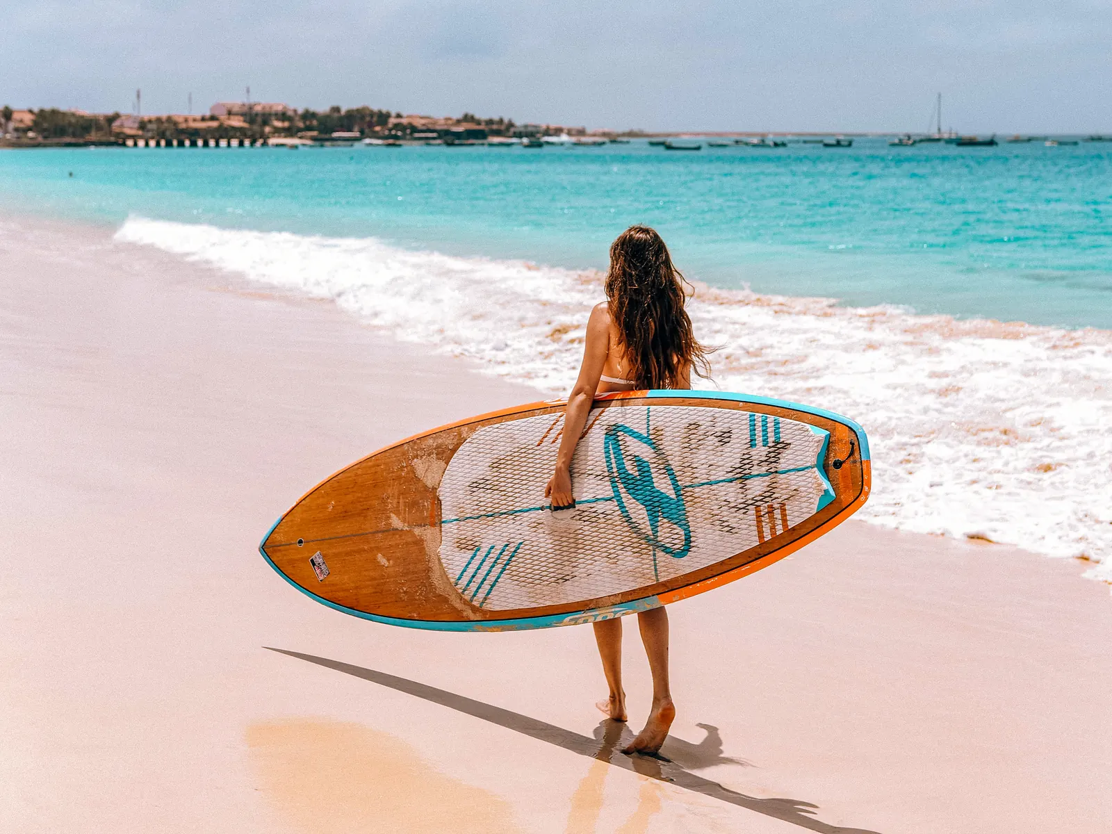 Plaża nad oceanem, kobieta z deską surfingową